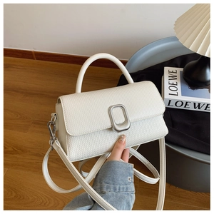 Detail of white woven texture handbag with silver metal lock and top handle