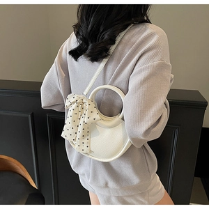 Vue arrière détaillée d'un sac bandoulière blanc en croissant avec foulard à pois chic