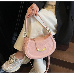 Pink lychee texture saddle bag with golden crescent buckle shown in a lifestyle setting