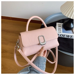 Pink woven texture handbag with round handle and metal buckle shown in a lifestyle setting