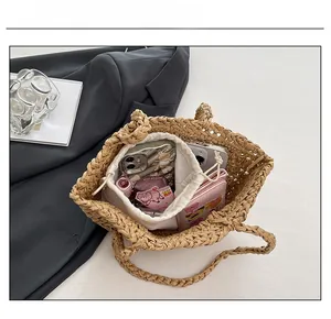 Detail view of woven straw tote bag capacity with canvas drawstring inner bag and daily items
