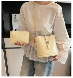 Détail d'un ensemble de sacs seaux jaune clair brillant avec bandoulière et pochette