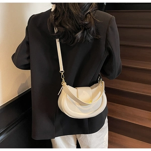 Detailed back view of white lychee texture saddle bag with dual straps and gold buckles