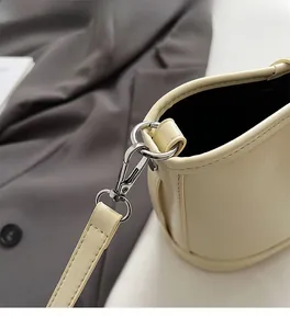 Détails de la quincaillerie en métal argenté et de la texture cuir crème du sac seau