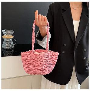 Detail of pink woven straw tote bag with textured V-pattern and drawstring lining