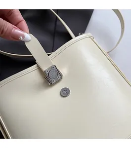 Détail de la fermeture magnétique pratique sur un sac seau en similicuir de couleur crème