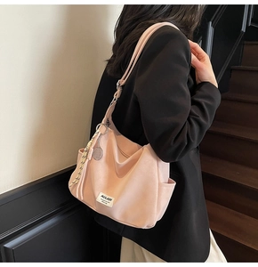 Detail of pink hobo bag with Mulaidi label, tennis racket charm and woven knot decor