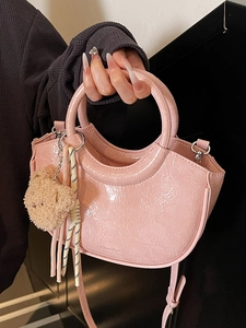 Pink patent leather bucket bag with glossy crinkle texture and cute bear pendant