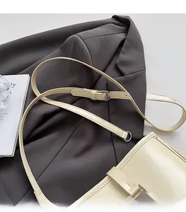 Détail de la bandoulière réglable en cuir avec boucles argentées du sac seau crème