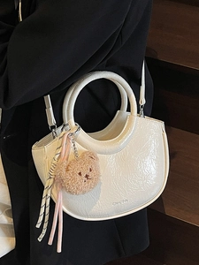 White crinkled leather bucket bag with top ring handle and cute plush bear charm