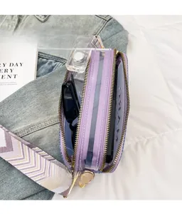 Vue détaillée de la trousse de toilette violette transparente avec bandoulière large