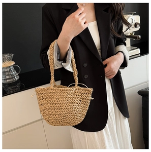 Detail view of straw handbag featuring V-shaped woven texture and secure drawstring lining