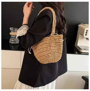 Detail of hand-woven straw tote bag with herringbone pattern and drawstring liner pouch