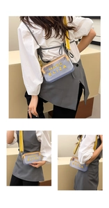 Détail du sac bandoulière en PVC violet transparent avec lettres jaunes et sangle