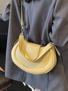 Litchi pattern leather saddle bag in pale yellow with crescent metal buckle on suit