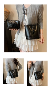 Vue détaillée du sac seau noir en cuir brillant avec pochette zippée et bandoulière