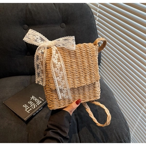 Detailed macro view of natural straw texture and large white lace bow on woven bag