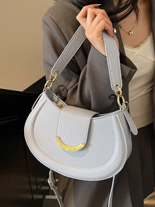 Elegant light blue lychee pattern saddle bag with gold crescent moon clasp on a model