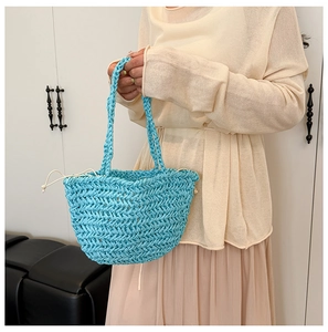 Detail of light blue straw woven bucket bag with herringbone pattern and drawstring closure