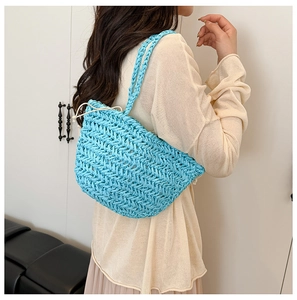 Detail of light blue hand-woven straw shoulder bag with white drawstring closure