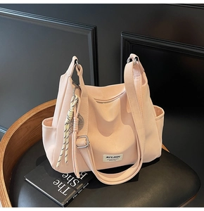 Detailed view of pink nylon tote bag with brand label and woven cord accessory