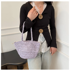 Close-up of light purple woven straw tote bag with textured herringbone pattern weave