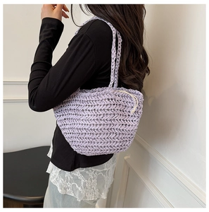 Detail of lavender woven straw bag featuring a cream drawstring liner and texture