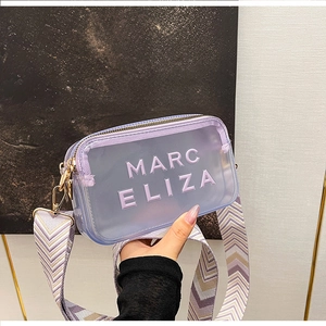 Détail du sac à bandoulière en PVC violet transparent avec logo et large sangle
