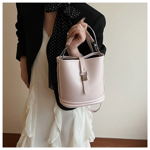Vue détaillée du sac seau en cuir rose clair avec boucles métalliques et bandoulière