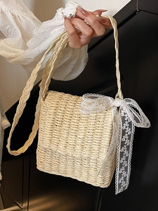 Beige straw crossbody bag with white lace bow detail for summer seaside vacation style