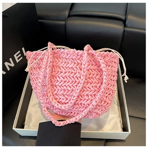 Detail of pink woven straw bucket bag showing delicate V-shaped texture and drawstring closure