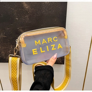 Détail du sac à bandoulière en PVC transparent avec sangle jaune et détails en métal