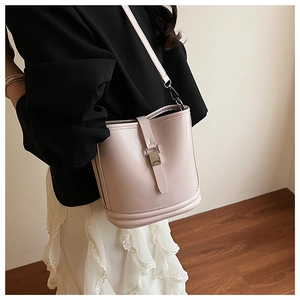 Détail d'un sac seau rose pâle avec boucle métallique et bandoulière réglable chic