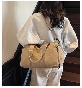 Rear view of model carrying khaki large nylon sports bag on stairs for short travel