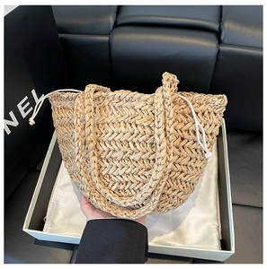 Detailed close-up of khaki woven straw tote bag featuring a secure white fabric drawstring liner