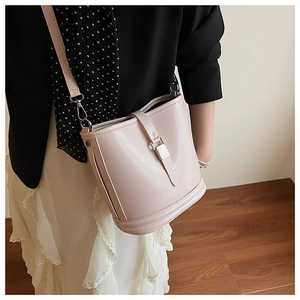 Détail du sac seau rose clair avec boucle en métal doré et finition en cuir lisse