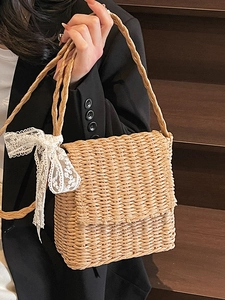 Handmade woven straw crossbody bag with white lace bow detail for summer vacation