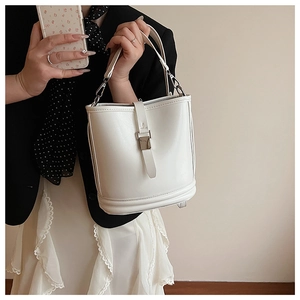 Détail d'un sac seau blanc en cuir avec boucle en argent et bandoulière amovible