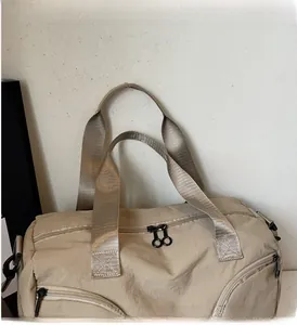 Detail of travel bag showing reinforced handles and durable metal zippers on beige fabric