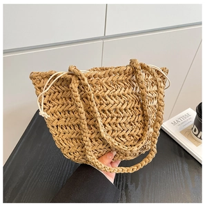 Detail of hand-woven straw tote with elegant V-pattern texture and cream drawstring