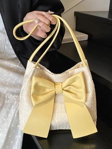 Sac cabas en paille crème avec un grand nœud jaune et fines lanières pour la plage
