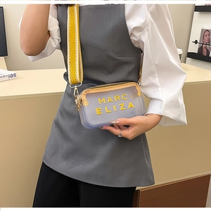 Détail du sac à bandoulière transparent avec sangle jaune et marquage Marc Eliza