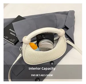 Interior detail of white woven dumpling bag showing space for phone and makeup items