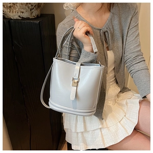 Détail d'un sac seau bleu clair avec boucle métallique et bandoulière réglable fine