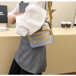 Vue détaillée du sac bandoulière gris transparent avec lettres jaunes et sangle tissée