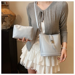Détail d'un ensemble de sacs seau bleu-gris clair avec pochette assortie et boucles en métal