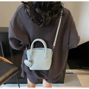 Back view of light blue lychee pattern bucket bag showing shoulder strap and heart charm