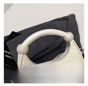 Detail of white woven leather hobo bag with thick handle and silver hardware
