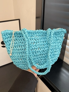 Bright blue handwoven straw tote bag with drawstring closure for casual summer vacations