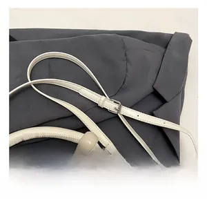 Detailed macro view of cream-colored faux crocodile texture and adjustable silver buckle